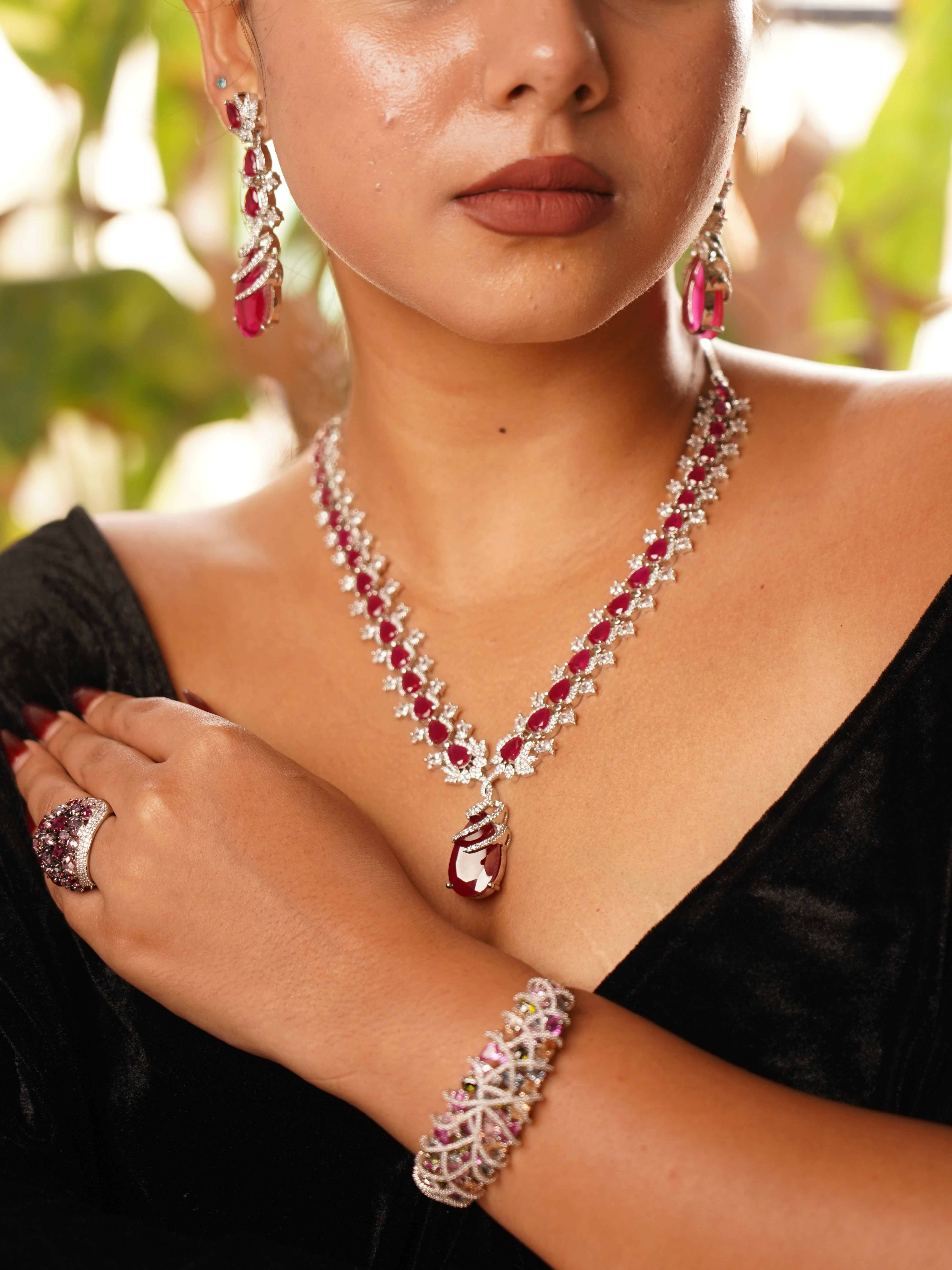 Angled view of ruby and diamond necklace showing symmetrical design and sparkle